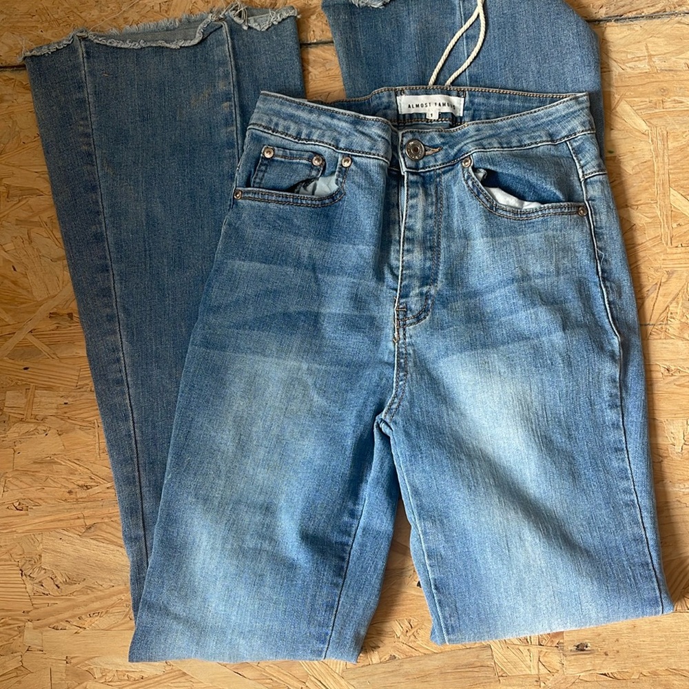 Almost Famous size 1 bootcut jeans with fringed bottom.